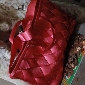 This one of a kind bag made from recycled seat belts in lavish silky red texture